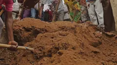 Pipo dey comot sand ontop grave wit shovel