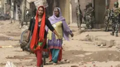 মুস্তাফাবাদে নিরাপত্তার সন্ধানে দু'জন নারী।