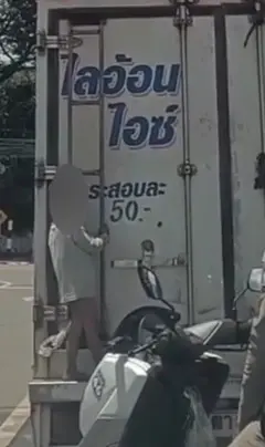 Criança pendurada na parte de trás de um caminhão