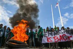 University students burn tyres as they protest against the arrival of Rohingya refugees in Banda Aceh on December 27, 2023.