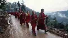 Monjes tibetanos caminan por una montaña