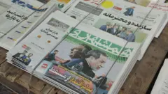 پیشخوان روزنامه فروشی و تصویر روزنامه‌های همشهری، ایران و دنیای اقتصاد