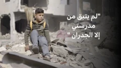 صورة لطفل يجلس على كومة من الحجارة