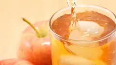 Copo de suco de maçã com gelo ao lado da fruta in natura
