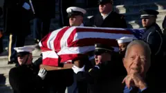 Jimmy Carter remains being carried by men in suits