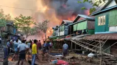 လေကြောင်းပစ်ခံရပြီး မီးလောင်နေတဲ့ နေအိမ်တွေကို မီးငြှိမ်းသတ်နေတဲ့ ကျောက်နီမော်ရွာခံအမျိုးသားတွေ