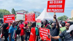 Protesters carry placards
