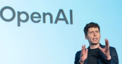 Sam Altman falando ao lado de uma placa da Open AI