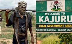 Agbébọn tó gbé ìbọn kọ́rùn pẹ̀lú àwòrán àkọ́lé tí wọ́n fi ń kí èèyàn káàbọ̀ sí ìjọba ìbílẹ̀ Kajuru