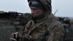 Український військовий зі смартфоном на передовій 