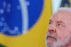Lula de perfil, com bandeira do Brasil ao fundo
