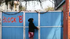 विद्यालयको ढोका बन्द गर्दै एक महिला कर्मचारी