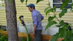 Homem ri ao colocar mangueira em tóneis com xixi