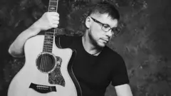 фото музиканта, він у чорній футболці з гітарою 