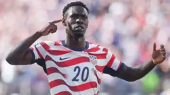  Folarin Balogun, de EE.UU. celebra uno de sus goles llevándose el dedo de la mano derecha a la oreja derecha. 