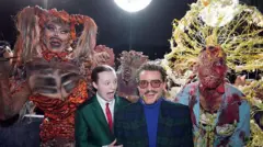 A imagem mostra um grupo de pessoas posando para fotos em um evento, cercadas por performers caracterizados como criaturas infectadas do universo de The Last of Us. À esquerda, há um ator fantasiado com um figurino grotesco, composto por grandes placas de fungo e tecidos deformados que cobrem todo o corpo. À direita, outro performer veste uma fantasia complexa, com uma grande estrutura dorsal que se assemelha a ramificações de fungo crescendo para fora da cabeça e das costas, criando um visual expansivo e detalhado. As fantasias são ricas em texturas, com cores que variam entre tons avermelhados, amarelados e marrons, lembrando carne infectada e crescimento fúngico. Os trajes chamativos contrastam com as roupas formais das pessoas no centro da imagem, reforçando o clima temático da pré‑estreia da série.