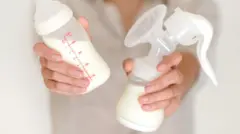 မိခင်နို့ရည် ပုလင်းကို ကိုင်ထားတဲ့ အမျိုးသမီးတစ်ဦး