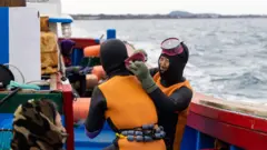 Duas haenyeo em um barco