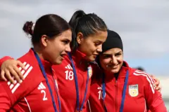 د افغان ښځينه لوبډلې درو لوبغاړو یوه بله په غېږ کې سره نېولې دي.