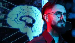 Um homem e uma imagem de um cérebro ao fundo