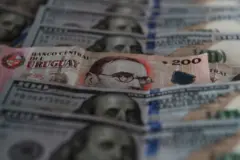 Billetes de dólares y pesos uruguayos