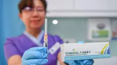 파란색 의료용 장갑을 낀 의료진이 '가다실 9' 백신을 들고 있는 모습