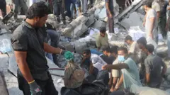 Pessoas e equipes de resgate trabalham entre os escombros após um ataque israelense a uma escola em Minab, no Irã, em 28 de fevereiro de 2026