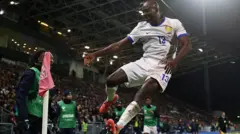 Jean-Philippe Mateta sorri ao saltar no ar, perto da bandeirinha de escanteio