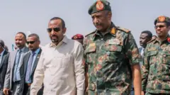 ቀዳማይ ሚኒስትር ኣብይ ኣሕመድ ኣብ ፖርት ሱዳን ብጀነራል ኣል-ቡርሃንን ካልኦት ሰብመዚን ኣቀባብላ ተገይርሉ