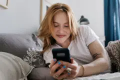 Mujer mirando el teléfono sonriendo