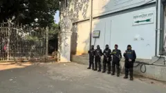 আন্তর্জাতিক অপরাধ ট্রাইব্যুনালের গেটের সামনে অস্ত্র হাতে দাঁড়িয়ে আছেন র্যাবের পাঁচজন সদস্য