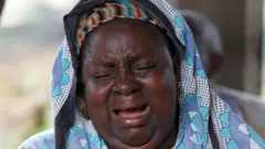 Woman whose family died in the cult crying 