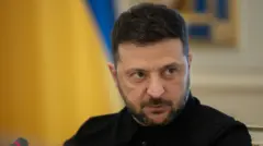 Володимир Зеленський дивиться в камеру на тлі розмитого прапора України