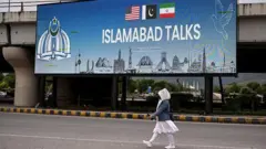 Bir kadın İslamabad Talks yazılı bir sokak ilanının önünden geçiyor. 