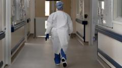Healthcare professional backwards walking down a hospital corridor