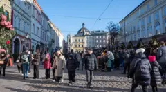 Місто львів, площа ринок, люди на вулиці одягнені в зимовий одяг