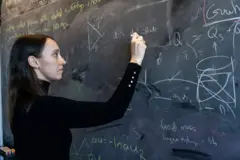 Sabrina González Pasterski escrevendo com giz em um quadro