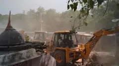 यमुना बाढ़ क्षेत्र में घरों पर चल रहे बुलडोज़र