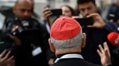 Cardeal cercado por jornalistas