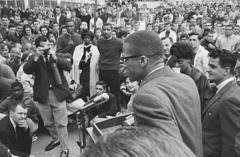 مالكولم إكس يتحدث أمام حشد في جامعة هارتفورد في ولاية كونيتيكت وقد تم نقل المحاضرة إلى الخارج عندما تضاعف عدد الحضور عن سعة القاعة التي كانت ستلقى بها المحاضرة