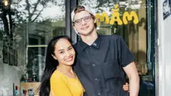 Vợ chồng Nhung Đào - Jerald Head chụp hình trước quán bún đậu tại New York