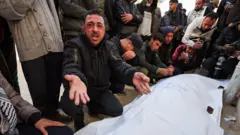 مشيعون يتفاعلون خلال جنازة فلسطينيين، بحسب مسعفين، قُتلوا في غارة إسرائيلية يوم السبت، في مستشفى الشفاء بمدينة غزة، 31 يناير/كانون الثاني 2026. 