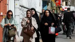 Un grupo de personas caminan apresuradas a refugiarse tras una explosión, después del inicio de los ataques de Estados Unidos e Israel contra Irán.