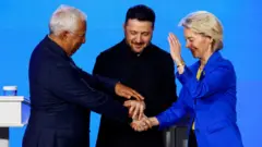 Takım elbiseli ik ierkek ve bir kadın ellerini birleştiriyor. Hepsi gülümsüyor. 