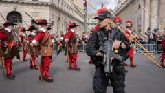 Geleneksel geçit töreni ve makinalı tüfekli polis