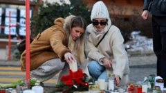 Des femmes déposent des bougies en hommage aux victimes du bar Le Constellation, après un incendie survenu lors d'une fête du Nouvel An