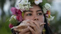 Mujer soplando una caracola