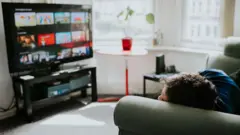 Criança olhando streaming na TV