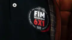 Close em um adesivo com a frase "fim da escala 6x1" em protesto em São Paulo MASP
