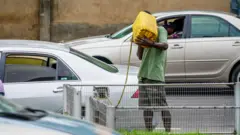 Man dey put fuel inside car from gallon